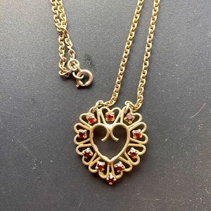 Golden heart necklace surrounded by red gemstones